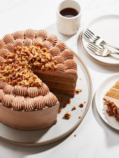 a chocolate cake with walnuts on top and one slice cut out from the cake