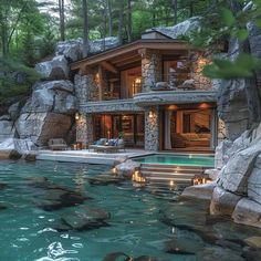 the house is surrounded by large rocks and has a swimming pool in front of it