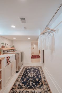 a room with a rug, sink and cabinets on the wall next to each other