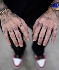 a man with tattoos on his hands and wrist