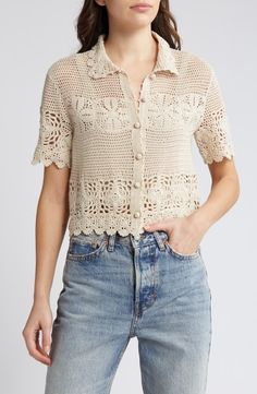 a woman wearing jeans and a crochet shirt