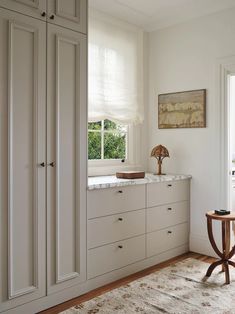 a room with white cupboards and a rug on the floor