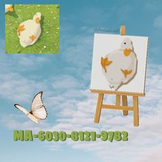 a white chicken sitting on top of a green field next to a painting easel