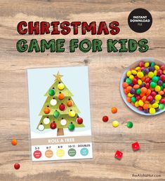 the christmas game for kids is on display next to a bowl of gummy balls