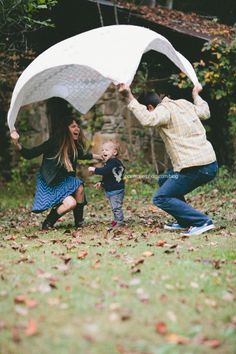 a family playing in the yard with an umbrella