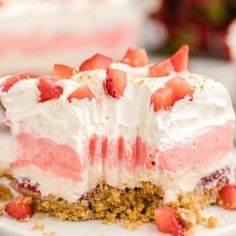 a piece of strawberry shortcake on a plate with the rest of the cake in the background