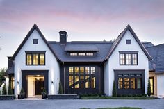 a large white and black house with lots of windows