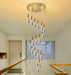 a chandelier made out of glass bottles hanging from the ceiling in a hallway