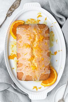 a white plate topped with a cake covered in orange slices