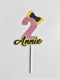 a pink and black number two cake topper on a white background with the word annie