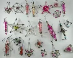 a collection of assorted pins and brooches on a white surface, all in different shapes and sizes