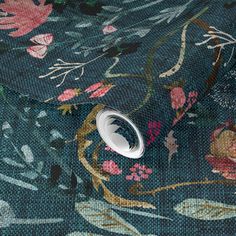 a close up view of the fabric with flowers and leaves on it's blue background