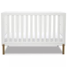 a white crib with wooden legs and no sheets on the bottom, against a white background