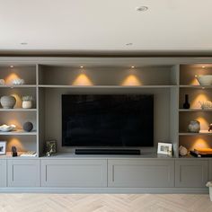 an entertainment center with built - in shelves and a flat screen tv on the wall