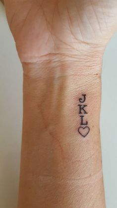 a small wrist tattoo with the letter kk on it