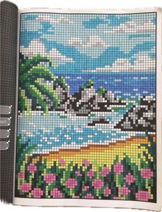 a cross stitch book with an image of flowers on the cover and water in the background