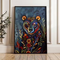 a painting of a bear is on the wall next to a plant and potted plant