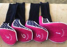 three pairs of pink and black tennis shoes with polka dots on them, sitting on a wooden surface