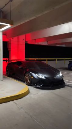 a black sports car parked in a parking garage