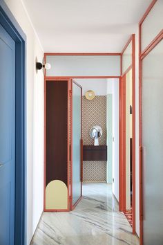 an open door leading to another room with a mirror on the wall and blue doors