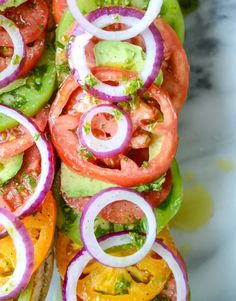 an open sandwich with tomatoes, onions and avocado