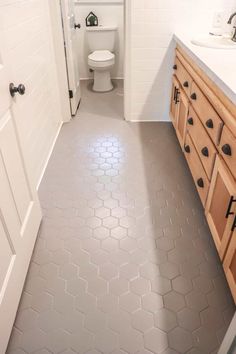 a bathroom with a toilet, sink and tiled floor