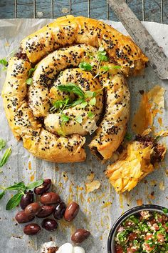 an assortment of food including bagels, olives and bread