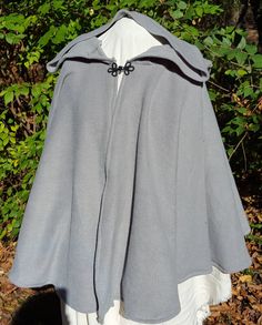 This short cloak is delightfully soft and comfortable. It's long enough to reach the back of the hand, keeping you warm but keeping your hands available when needed. It has a full hood and closes with a matching cloth frog clasp. This cloak is great for a costume piece or a cozy jacket, great for Spring, Fall, or over air conditioned buildings. Your cloak will measure about 30 inches in length. This listing is in a medium grey, but other colors are available in my store or on request. The materi Winter Outdoor Cape, Solid Hooded Cape For Fall, Hooded Fall Cape For Larp, Hooded Cape For Larp In Fall, One-size Hooded Outerwear For Outdoor, One Size Hooded Outerwear For Outdoor, One Size Outdoor Cape Outerwear, One Size Winter Outerwear For Outdoor, One Size Cape For Outdoor