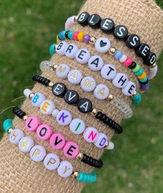 a stack of bracelets with the words breathe and love spelled on them in different colors