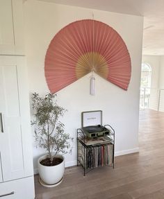 a room with a plant, record player and fan on the wall next to it