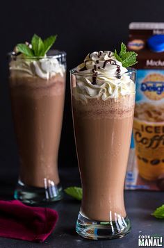 two glasses filled with chocolate milkshakes and whipped cream