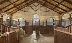 the inside of an old building with hay bales on the floor and railings