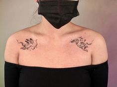 a woman with tattoos on her chest wearing a black face mask and looking at the camera