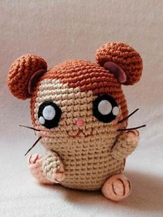 a small crocheted rat sitting on top of a white table next to a wall