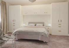 a bedroom with white furniture and beige carpet