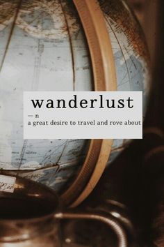 a globe with the words wanderlust on it sitting next to some other items