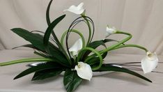 white flowers are arranged in a vase on a table