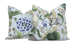 two blue and green pillows with flowers on them, one has a bird in the middle