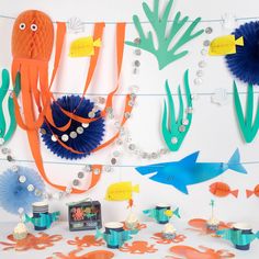 an assortment of sea creatures are displayed on a wall with beads and other items around it