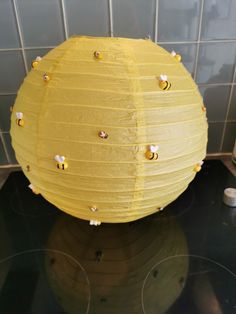 a yellow paper lantern sitting on top of a stovetop next to a tiled wall