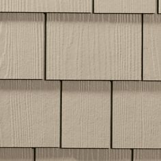 a close up view of the side of a house with white siding and wood shingles