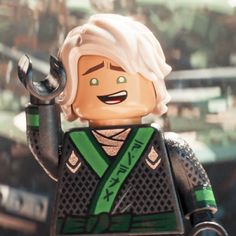 a lego man with white hair and green vest holding a wrench in his right hand