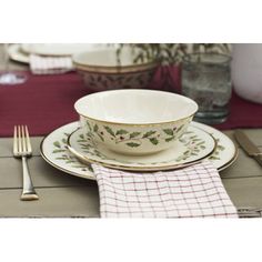 a table set with dishes, silverware and napkins