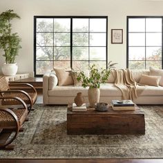 a living room filled with furniture and large windows