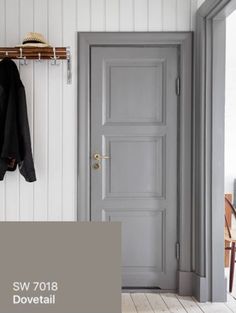 an open door and coat rack in a white room