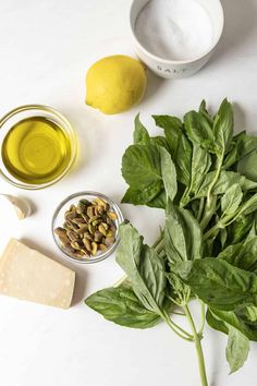 spinach leaves, lemons and other ingredients on a white surface