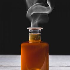 a bottle filled with liquid sitting on top of a wooden table