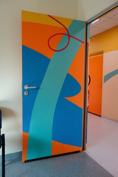 an open door with a painting on it in a room that is painted orange, blue and green