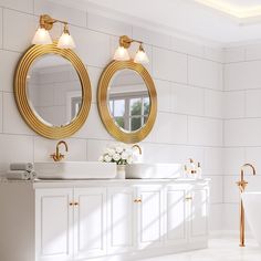 a bathroom with two round mirrors above the sinks and a bathtub in front of it