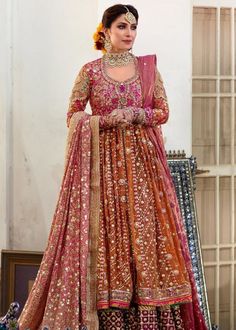 a woman in a red and gold lehenga